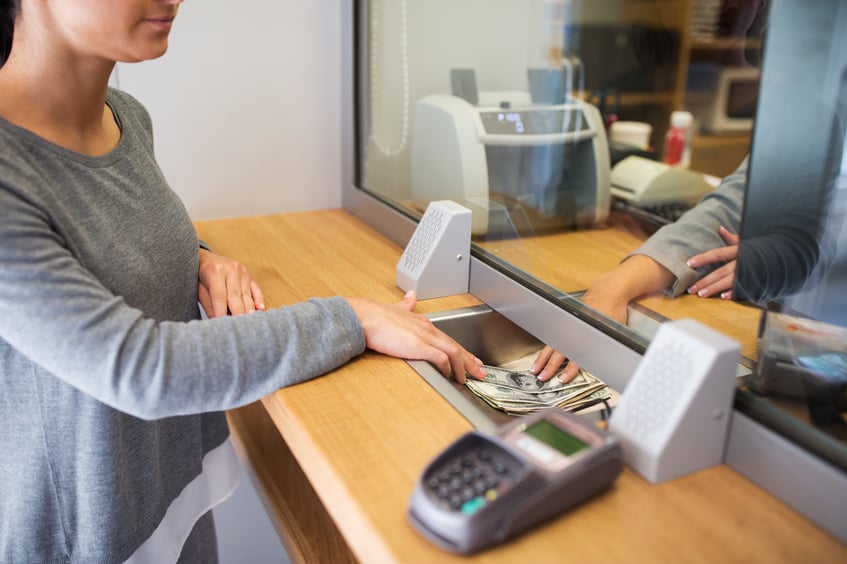 Woman giving money to banker