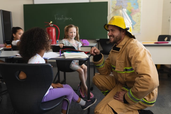 Firefighter talking to elementary students